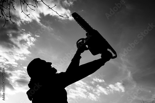 Silhouette of a man with a chainsaw