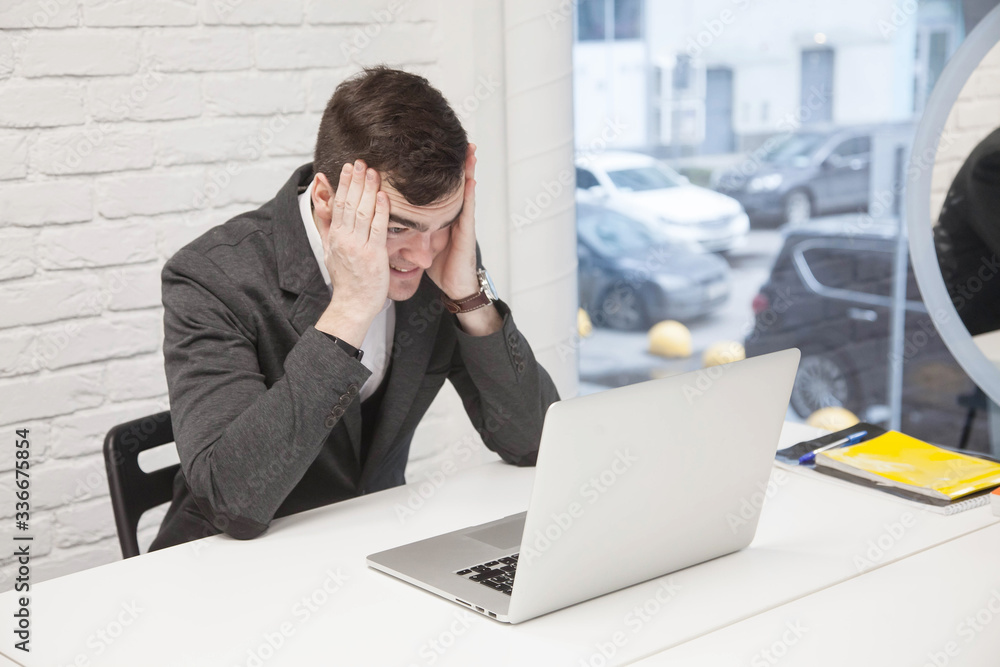 young businessman works in an office with a laptop young businessman works in an office with a laptop