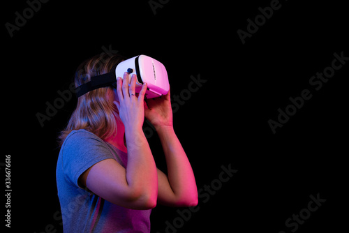 Tableau sur toile Chica de perfil con unas gafas de realidad virtual sobre un fondo negro y colores