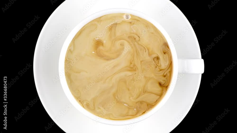 Cup of coffee top view. Hot cream is poured into coffee and turned into a beautiful liquid pattern. Close-up. Fluid in motion. 4K UHD video 3840x2160 Cup of coffee top view. Hot cream is poured into coffee and turned into a beautiful liquid pattern. Close-up. Fluid in motion. 4K UHD video 3840x2160