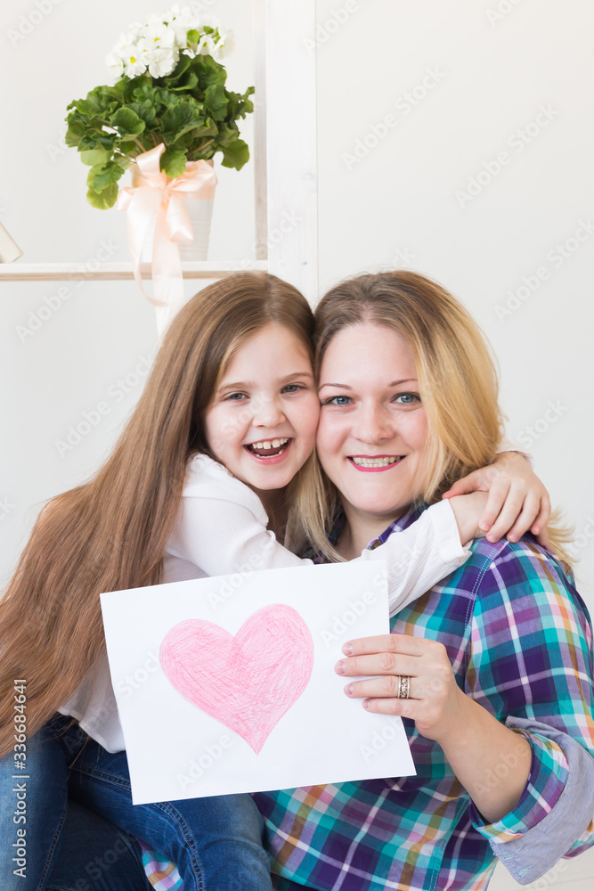 Mother's Day and family holidays - Mother reading greeting card from her daughter. Mother's Day and family holidays - Mother reading greeting card from her daughter.