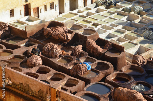 Chouara Tannery is one of the three tanneries in the city of Fez, Morocco. Built in the 11th century, the largest tannery in the city. Worker working on the leather dying.