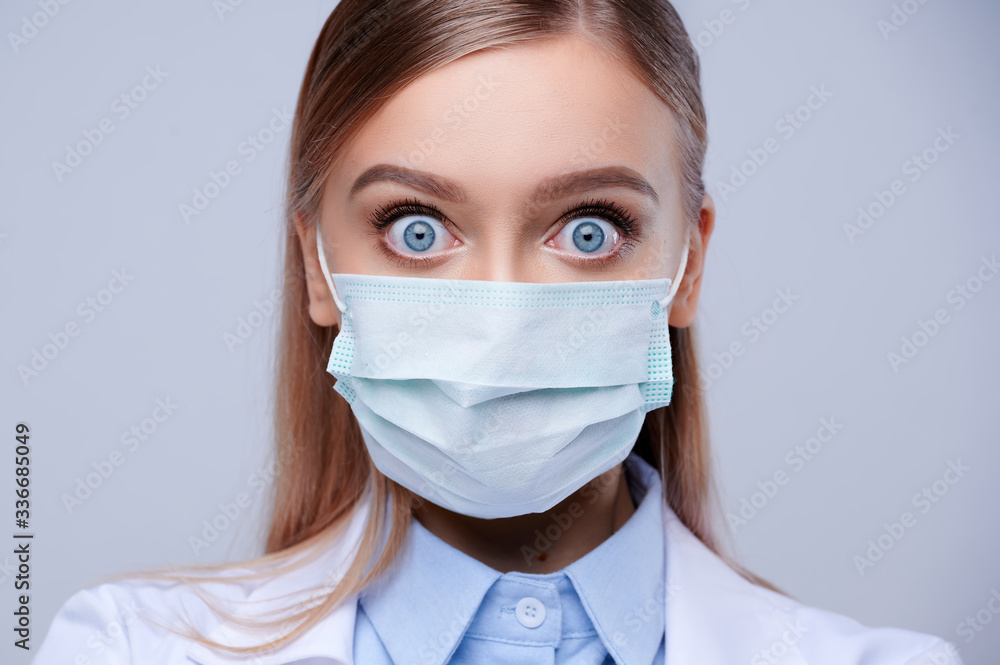 Close-up face of masked doctor with surprise and wide open eyes. Close-up face of masked doctor with surprise and wide open eyes.