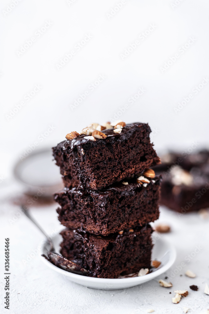 Chocolate brownie with nuts on paper on white background Chocolate brownie with nuts on paper on white background