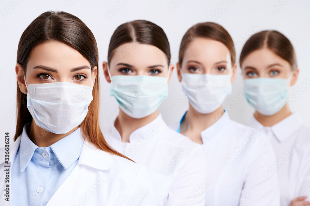 Group of female doctors with face masks looking at camera, corona virus concept. Group of female doctors with face masks looking at camera, corona virus concept.