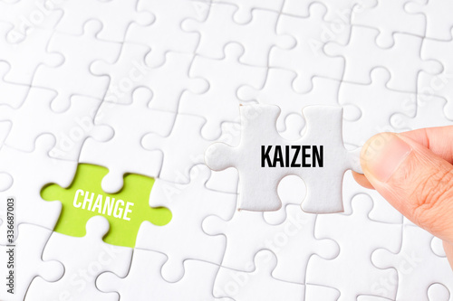 The kaizen word on white jigsaw go to replace change word on green gap - idea answer concept.