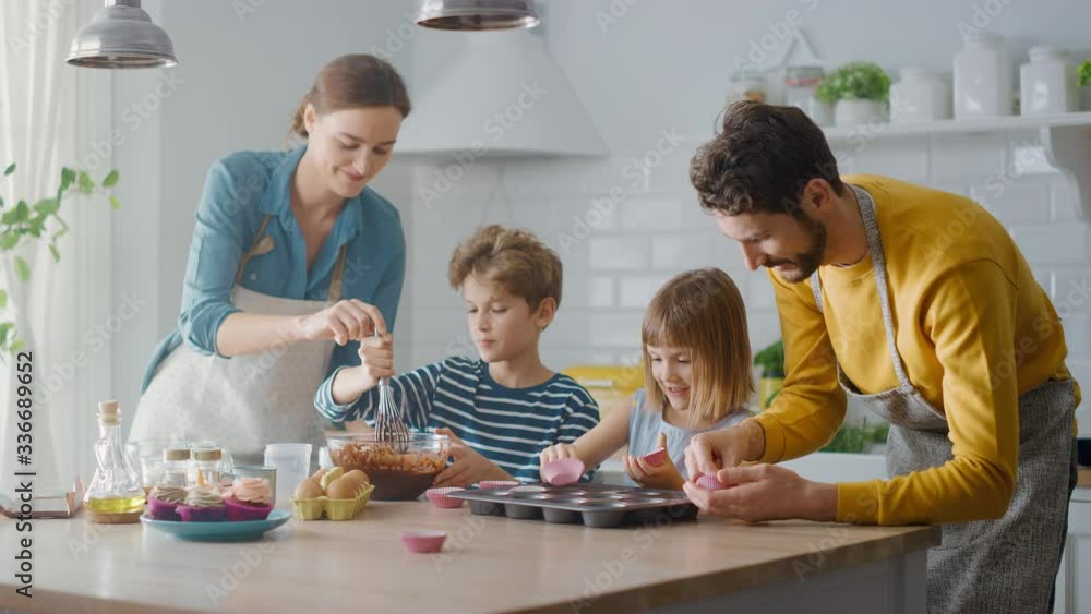 In the Kitchen: Family of Four Cooking Muffins Together. Mother and Daughter Mixing Flour and Water to Create Dough for Cupcakes, Father, Son Preparing Paper Lines for Pans. Children Helping Parents
In the Kitchen: Family of Four Cooking Muffins Together. Mother and Daughter Mixing Flour and Water to Create Dough for Cupcakes, Father, Son Preparing Paper Lines for Pans. Children Helping Parents