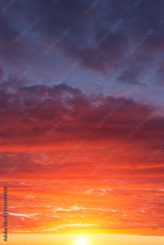 Naklejka premium Epic dramatic sunset, sunrise red orange sky with clouds, sun and sunlight