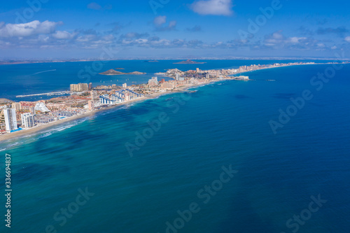 Aerial drone photo of The Sandbar of the Minor Sea, "La Manga" in Spain which is a tiny strip in the middle of the sea with resorts and a beautiful skyline © iAmTasweer