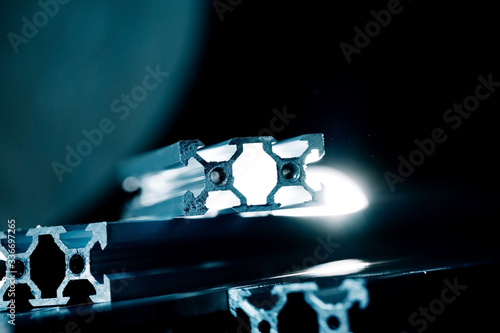 Εκτύπωση καμβά v slot aluminum profile lies on a black table, work surface with a bright lantern