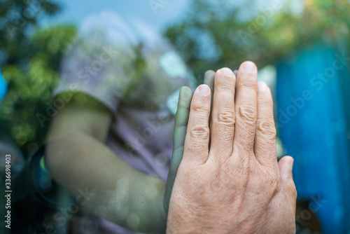 Social distancing among the family, hand of the mother and daughter on a window plane, concept coronavirus,covid-19,Work from home (WFH), Social distancing, Quarantine, Prevent infection concept. photo