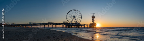 Slika na platnu A panoramic shot of the sun setting beside the Pier in Scheveningen with the fer