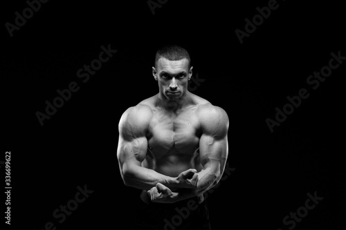 Muscular model sports young man in jeans showing his press on a black background. Fashion portrait of sporty healthy strong muscle guy. Sexy torso.  Black and white photography  © kiy_lg
