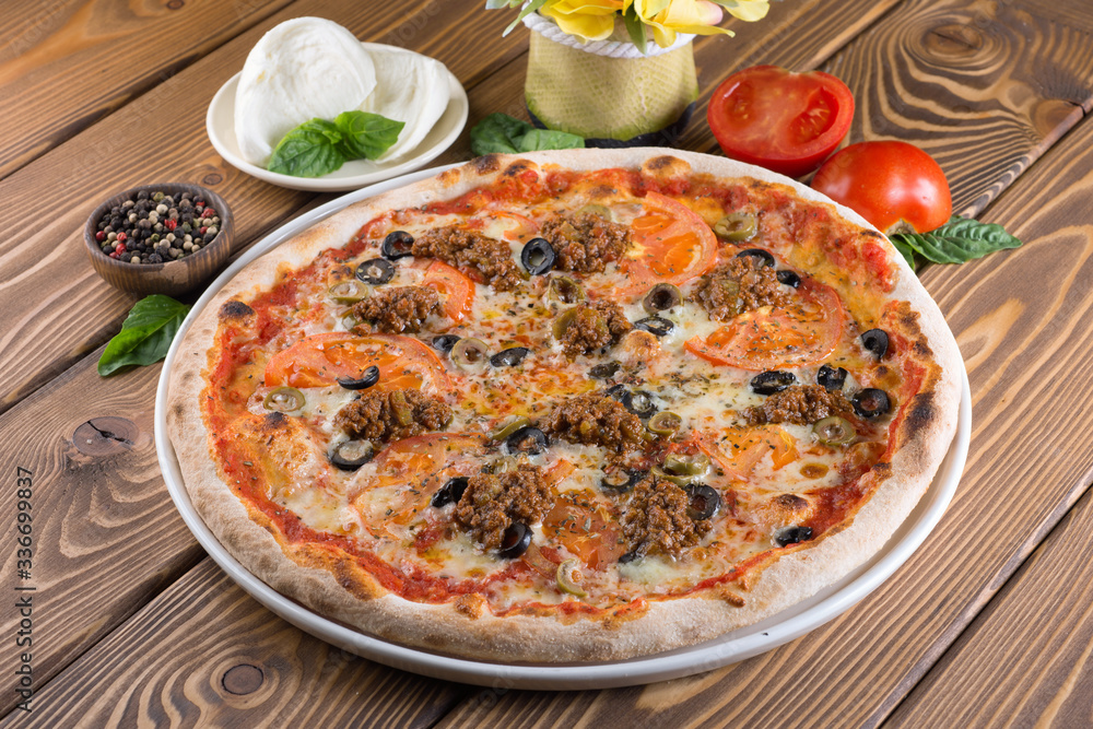 Delicious pizza with cheese, tomatoes, olives and greens Delicious pizza with cheese, tomatoes, olives and greens