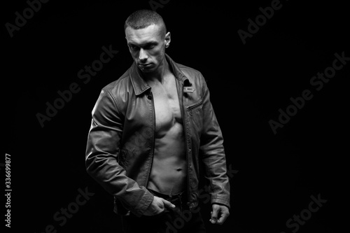 Sexy torso.  Fashion portrait of sporty healthy strong muscle guy.  Muscular model sports young man in jeans showing his press on a black background. Black and white photography  © kiy_lg