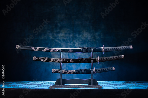 Photos Three swords on stand, with dramatic blue light