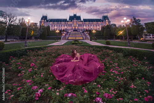 Beautiful woman in roses garden near castle