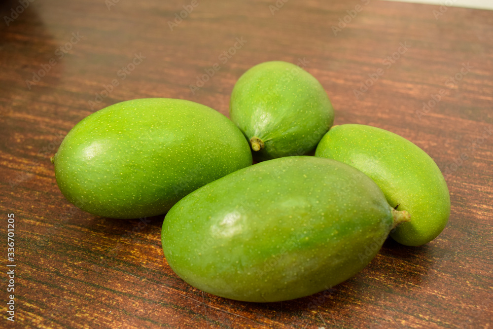 Organic Young Green Mangoes on Wooden Table sour fruits. Organic Young Green Mangoes on Wooden Table sour fruits.