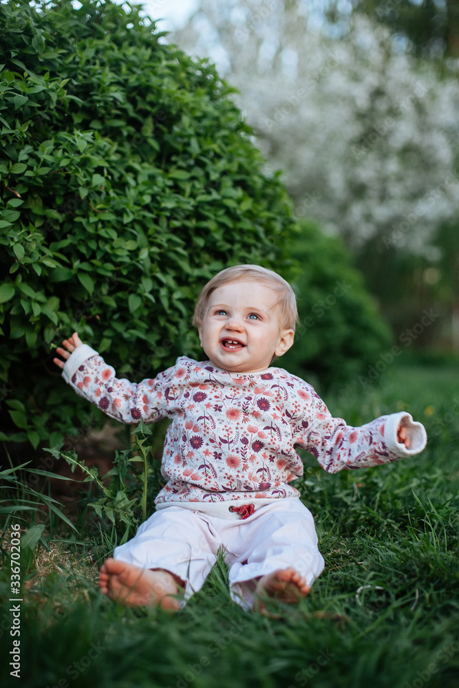 little one-year-old girl in spring garden. little one-year-old girl in spring garden.