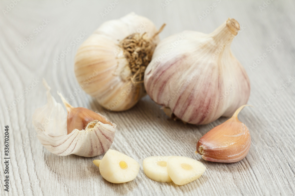 Raw garlic bulbs on a gray wooden background. Raw garlic bulbs on a gray wooden background.