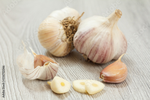 Raw garlic bulbs on a gray wooden background.