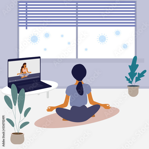 Woman doing yoga activity at home, studying class distance. Online sports training on laptop during the coronavirus pandemic.