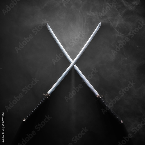 Two katanas with crossed blades in dramatic smoke