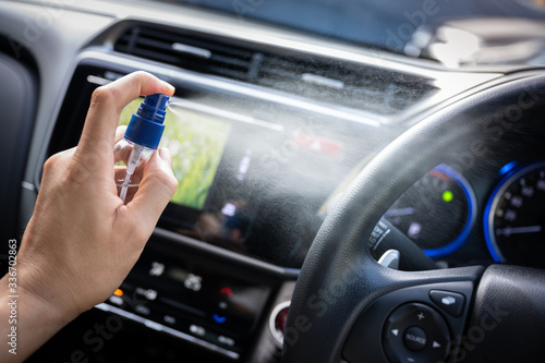 Man is spraying alcohol,disinfectant spray in car for prevention coronavirus disease (covid-19) contamination of germs and wipe clean surface, health care concept (select focus) © PhotobyTawat