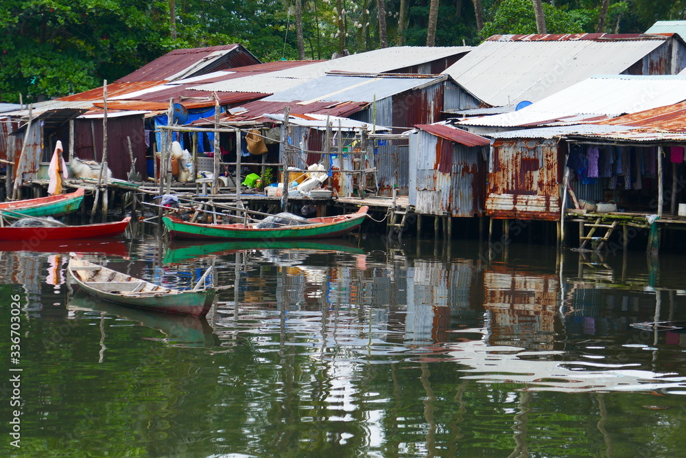 fishing boats in front of stilt houses