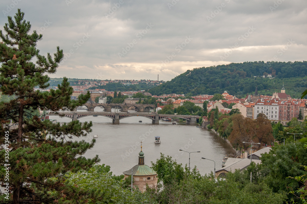 Beautiful and picturesque view of the city and the bridge over the river from the high mountain. Tourist ships on the river. The town is surrounded by green hills with forest.