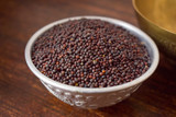 Mustard seeds in a Silver bowl on wooden old Table. Rustic Style