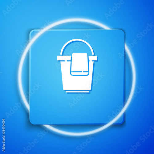 White Bucket with rag icon isolated on blue background. Cleaning service concept. Blue square button. Vector Illustration