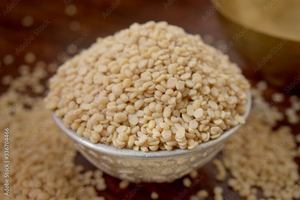 Split White Urad Dal. Vigna mungo Beans in a Silver bowl on wooden old Table. Rustic style Split White Urad Dal. Vigna mungo Beans in a Silver bowl on wooden old Table. Rustic style