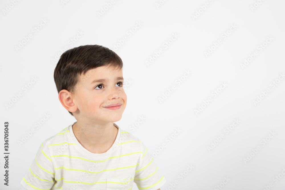 happy little boy looks sideways on white background happy little boy looks sideways on white background