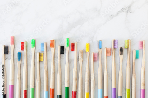 Multi-colored bamboo toothbrushes for adults and children, eco-friendly bathroom. Healthy teeth and a clean planet without plastic. Light background with place for text.