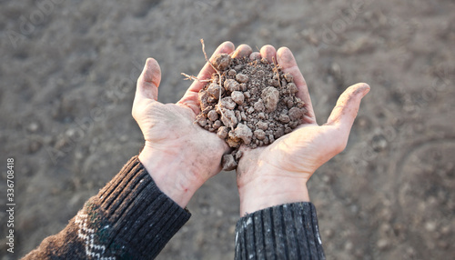 The man is holding the very dry soil in his palm. Concept of soil erosion due to lack of precipitation due to global warming