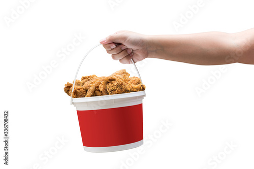 A hand holding a bucket of crispy fried chicken on a white background