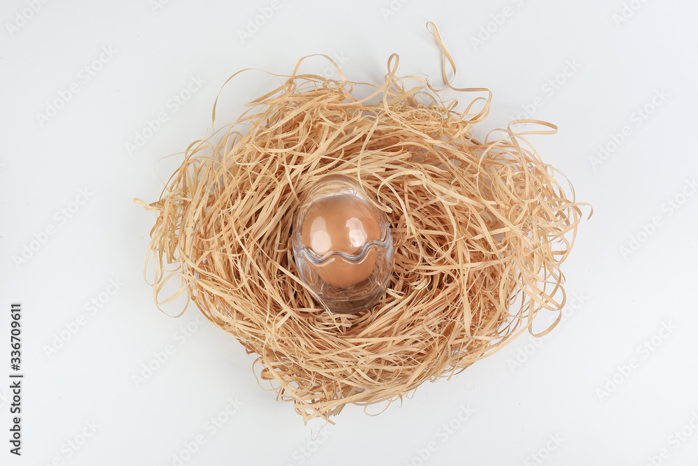 Egg in egg shape glass container protection shell on white background safety security straw nest Egg in egg shape glass container protection shell on white background safety security straw nest