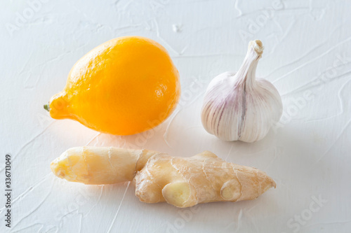 Ginger, garlic and lemon - a means to protect against viral infection and colds on a light wooden table. Copy space. Close-up