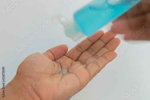 hand has blue alcohol, squeezed out of bottle into  hand