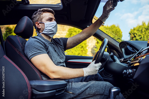 Man with protective mask and gloves driving a car. Infection prevention and control of epidemic. World pandemic. Stay safe. © dusanpetkovic1