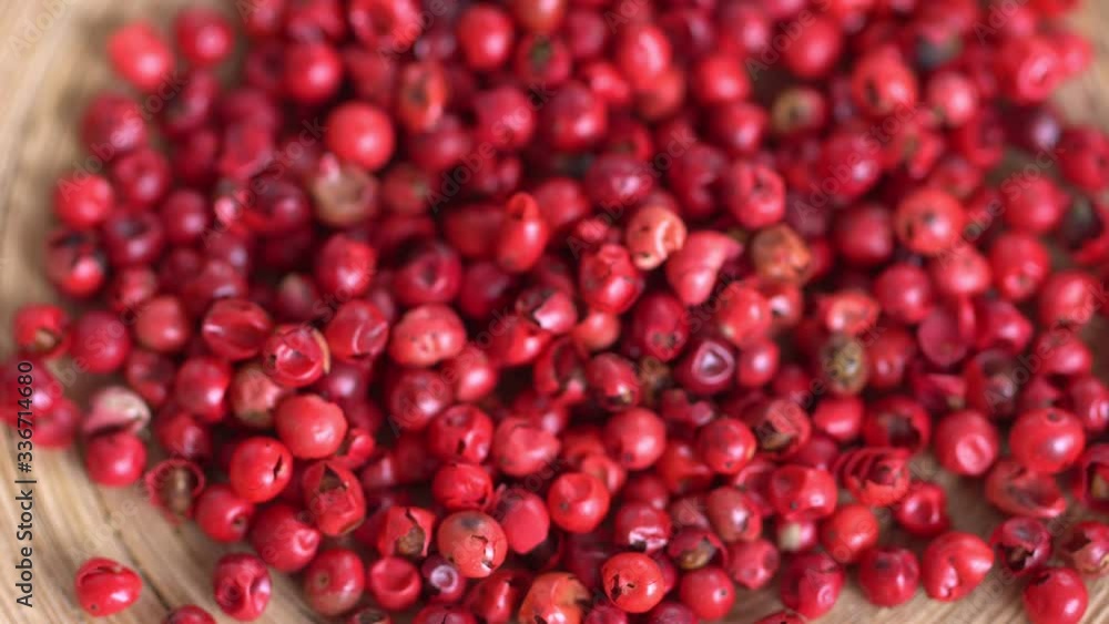 pink peppercorns placed on a kitchen table. Rotation. Falling. Extreme macro of a Himalayan pepper berries. concept of fresh and dietary spices for cooking schools and vegans and dietary products. pink peppercorns placed on a kitchen table. Rotation. Falling. Extreme macro of a Himalayan pepper berries. concept of fresh and dietary spices for cooking schools and vegans and dietary products.