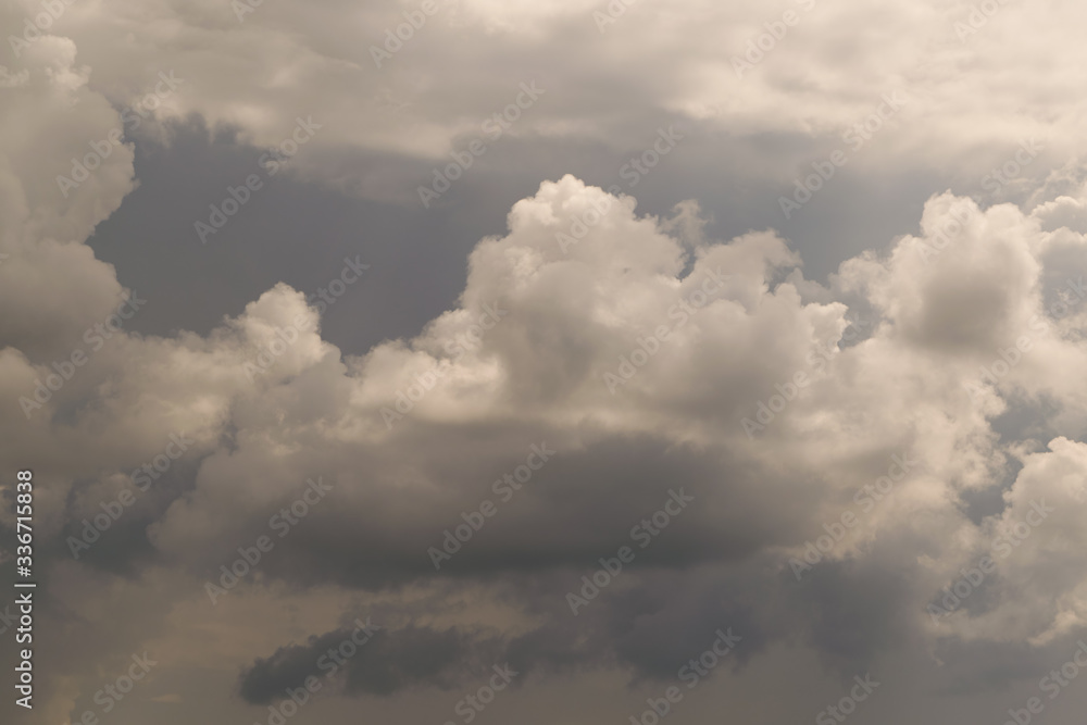 Huge storm clouds high in the sky. Overcast. Below, under dark clouds, it is raining. On top of large Cumulus clouds. Background, backdrop.