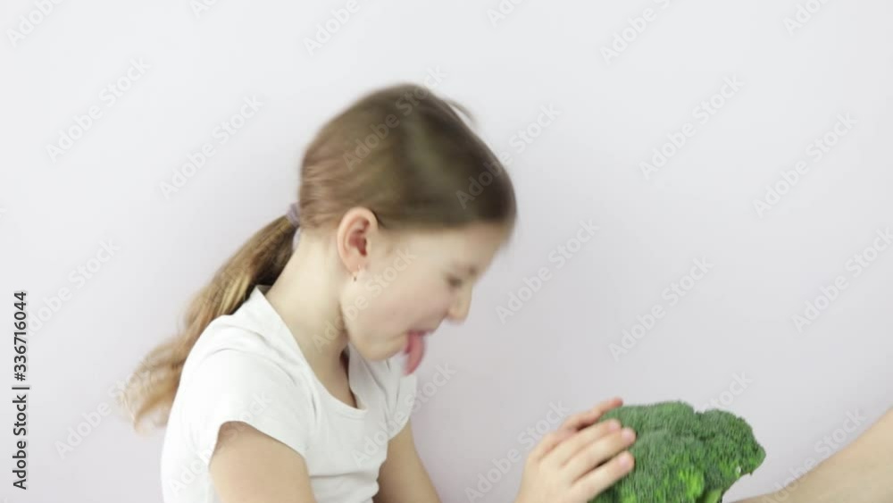 girl refuses broccoli, does not want to eat broccoli. shows that raw vegetables are tasteless. girl refuses broccoli, does not want to eat broccoli. shows that raw vegetables are tasteless.