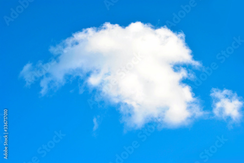 One fluffy cloud and blue sky on the sunny day. Good mood concept. Fresh air and well weather