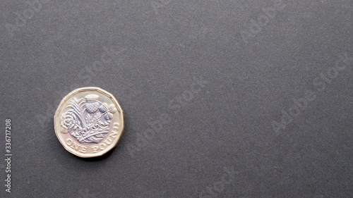 British new pound coin spinning and rolling on dark background