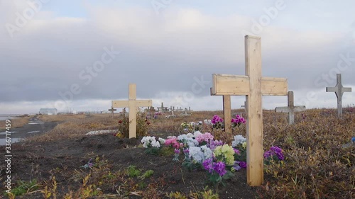 The cemetery in Kivalina, Alaska filled with wooden headstones and flowers photo