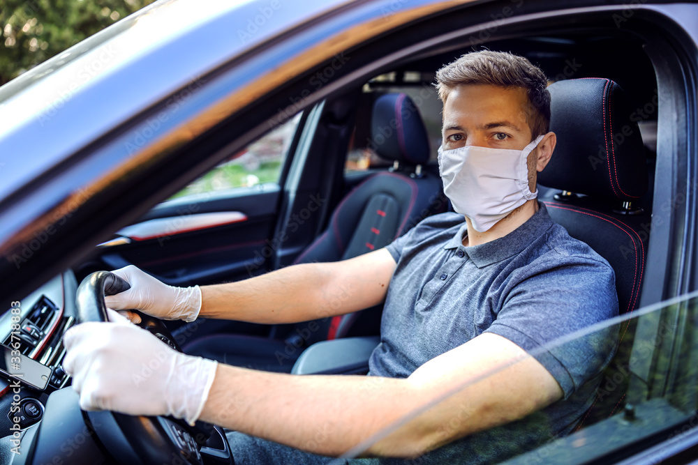 Man with protective mask and gloves driving a car. Infection prevention and control of epidemic. World pandemic. Stay safe. Man with protective mask and gloves driving a car. Infection prevention and control of epidemic. World pandemic. Stay safe.