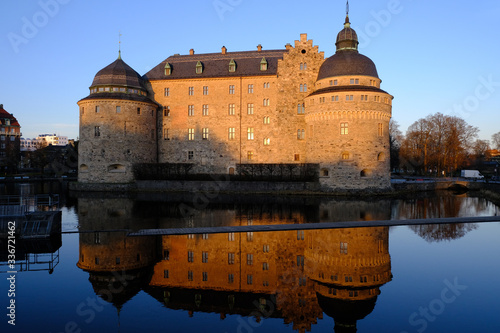Bild auf Leinwand Orebro castle and reflection at sunset, Orebro, Sweden
