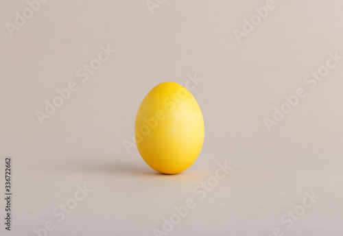 Yellow egg on beige pastel background